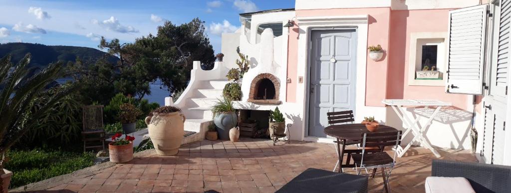 un patio avec une table et des chaises et un bâtiment dans l'établissement Casa Carmela, à Ponza