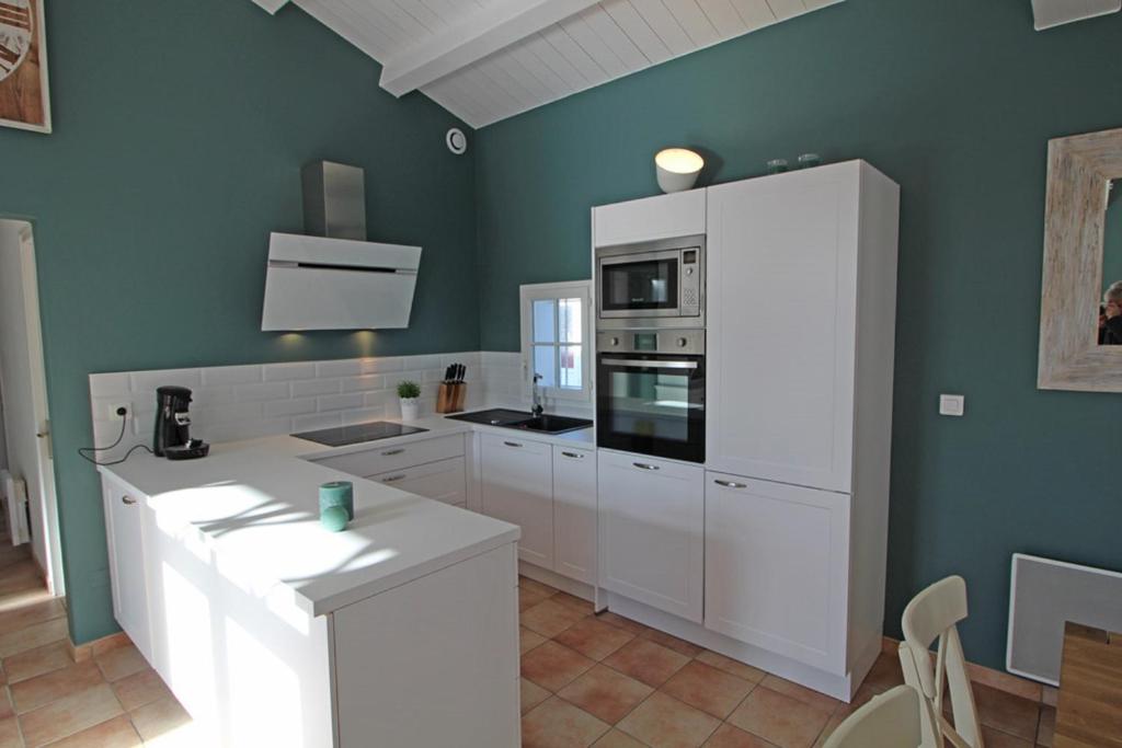 a kitchen with white appliances and green walls at Résidence La Chaize in Noirmoutier-en-l'lle