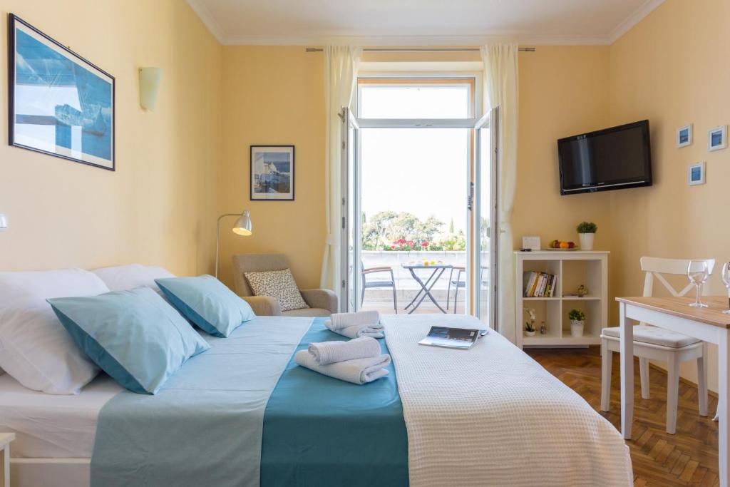 a bedroom with a large bed with a table and a window at Villa Benic in Dubrovnik