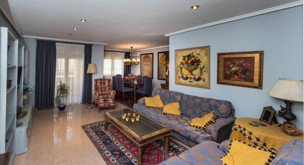 een woonkamer met blauwe banken en een tafel bij Apartamento Completo in Monóvar