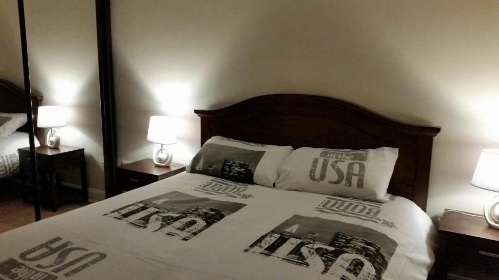 a bed in a room with two lamps and a mirror at Apartment 2 Oakleigh House in Cork