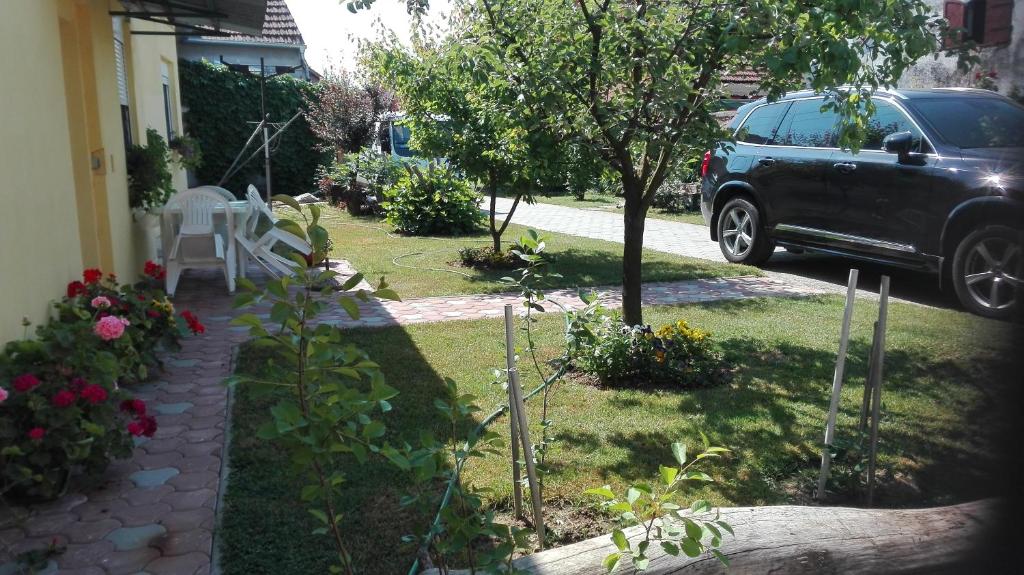 un patio con un coche estacionado al lado de una casa en Apartman Peric, en Ðakovo