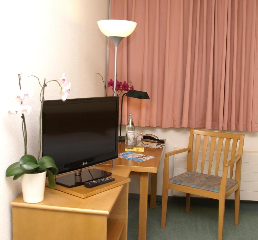 Televiisor ja/või meelelahutuskeskus majutusasutuses Apart Hotel Gera
