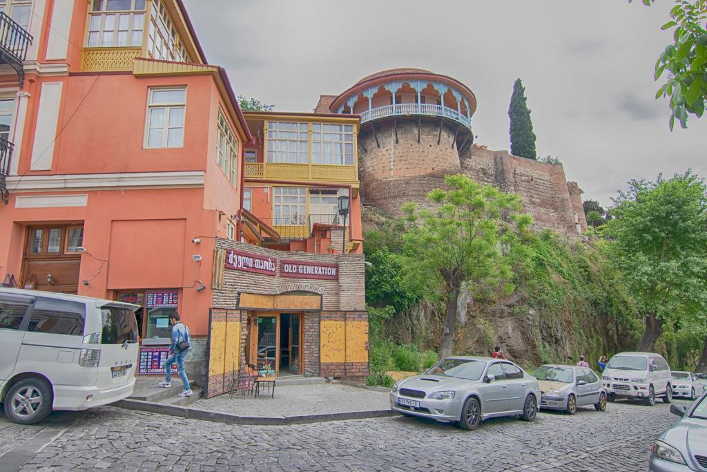 Un edificio con coches aparcados delante. en Art Apartment, en Tiflis