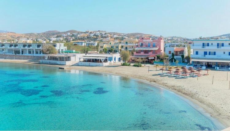 a view of a beach with chairs and buildings at Soulas apart -Ρέα- in Ano Syros