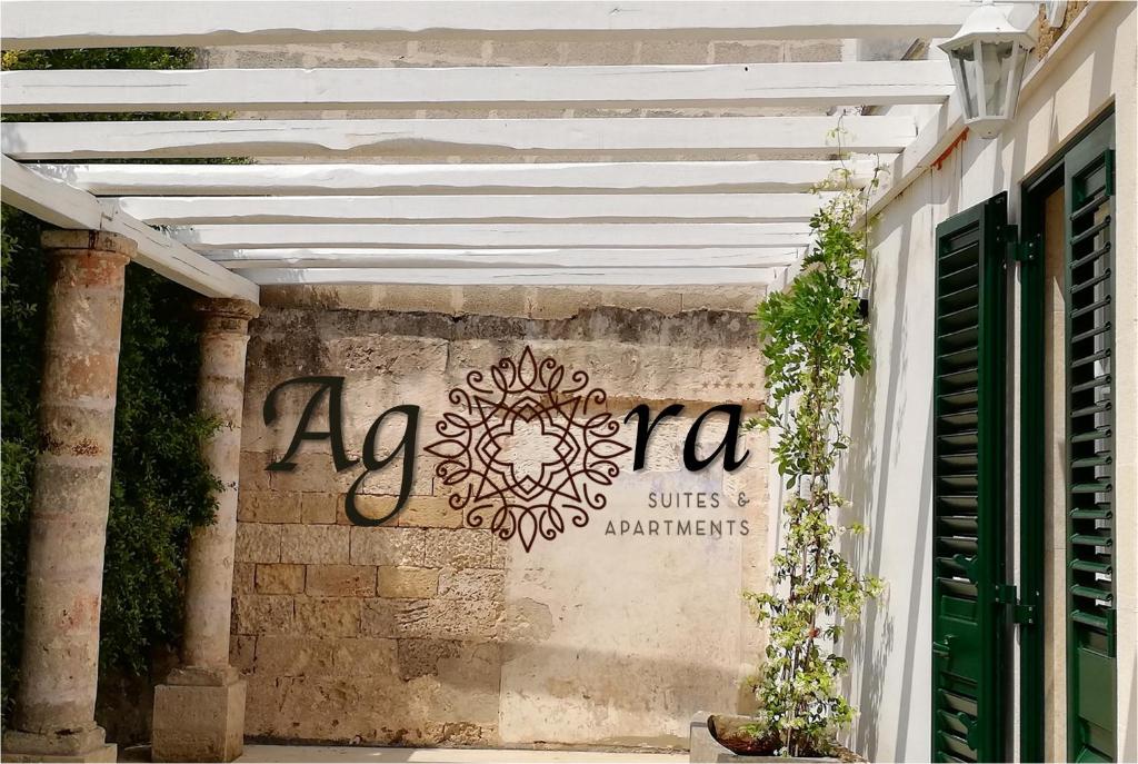 una pérgola blanca con un cartel en la pared en Agorà Suites & Apartments, en Manduria