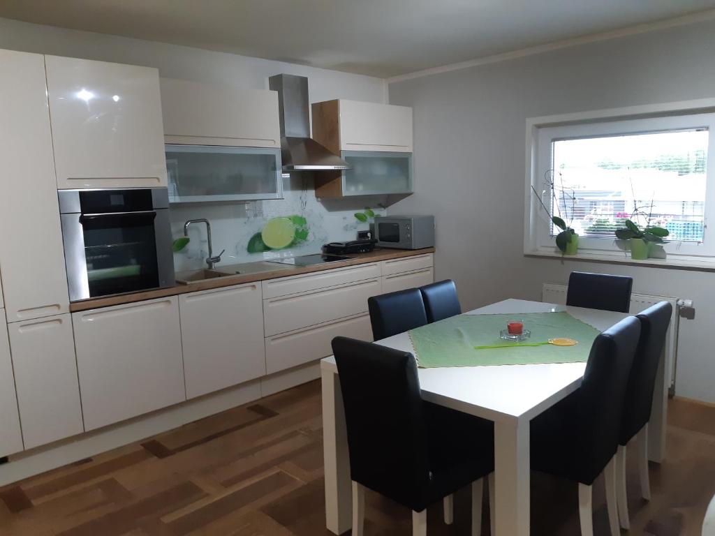 eine Küche mit einem Tisch und Stühlen im Zimmer in der Unterkunft Sanja apartment near to Ljubljana in Preserje pri Radomljah