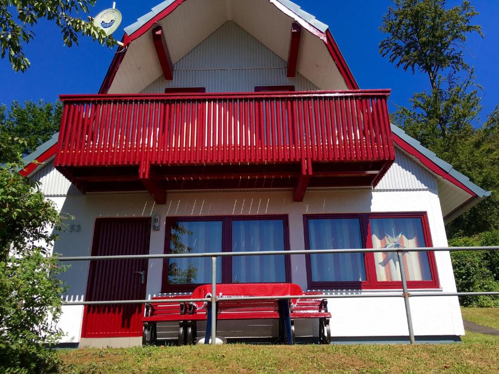 ein rotes und weißes Haus mit einem roten Balkon in der Unterkunft Rotkäppchen @ Seepark Kirchheim in Kirchheim