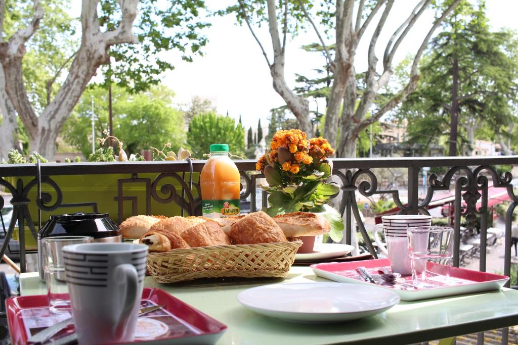 una mesa con una cesta de pan y flores. en Chez Marie Louise, en Pézenas