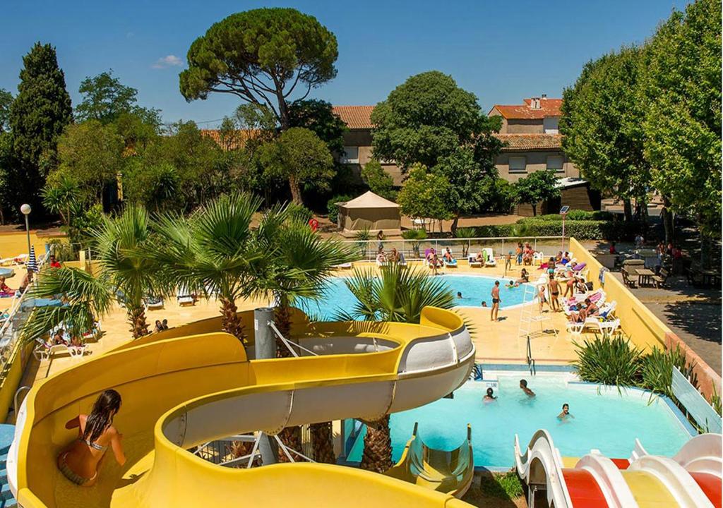 una gran piscina con gente en un complejo en Mobilhome Climatisé 3CH 6P dans Parc des 7 Fonts en Agde