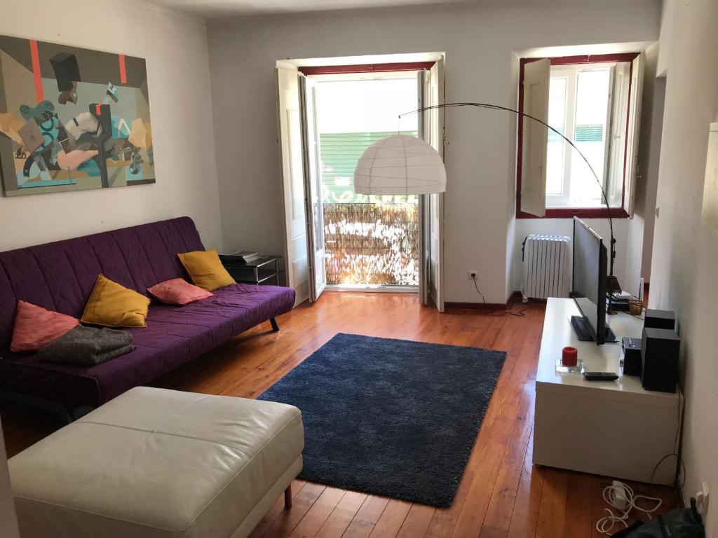 - un salon avec un canapé violet et un tapis bleu dans l'établissement #Tram28_Cosy, à Lisbonne
