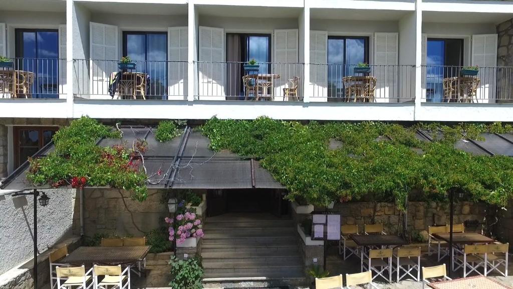 a building with a staircase and tables and chairs at Hotel Restaurant Sole E Monti in Quenza