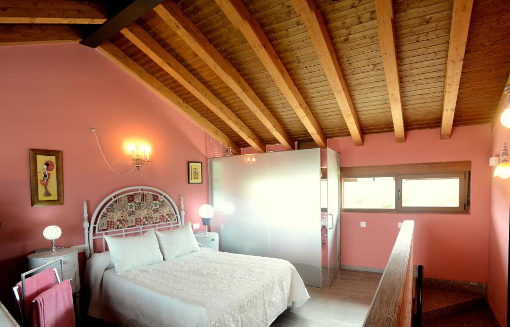 um quarto com uma cama branca e paredes cor-de-rosa em El Carmen Fresa em Marlín