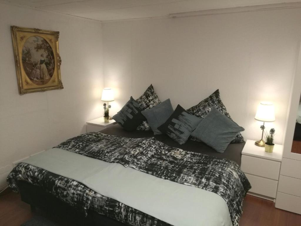 Schlafzimmer mit einem Bett mit schwarzen und weißen Kissen in der Unterkunft Apartment Cosmelux Nürnberg in Nürnberg