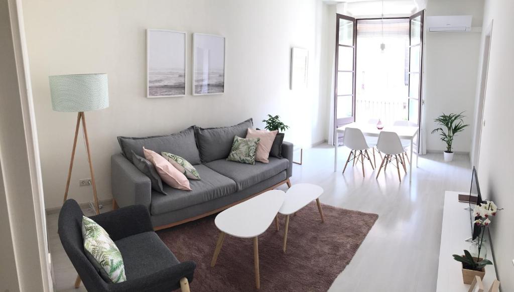 タラゴナにあるAmplio y luminoso apartamento con vistasのリビングルーム(ソファ、テーブル、椅子付)