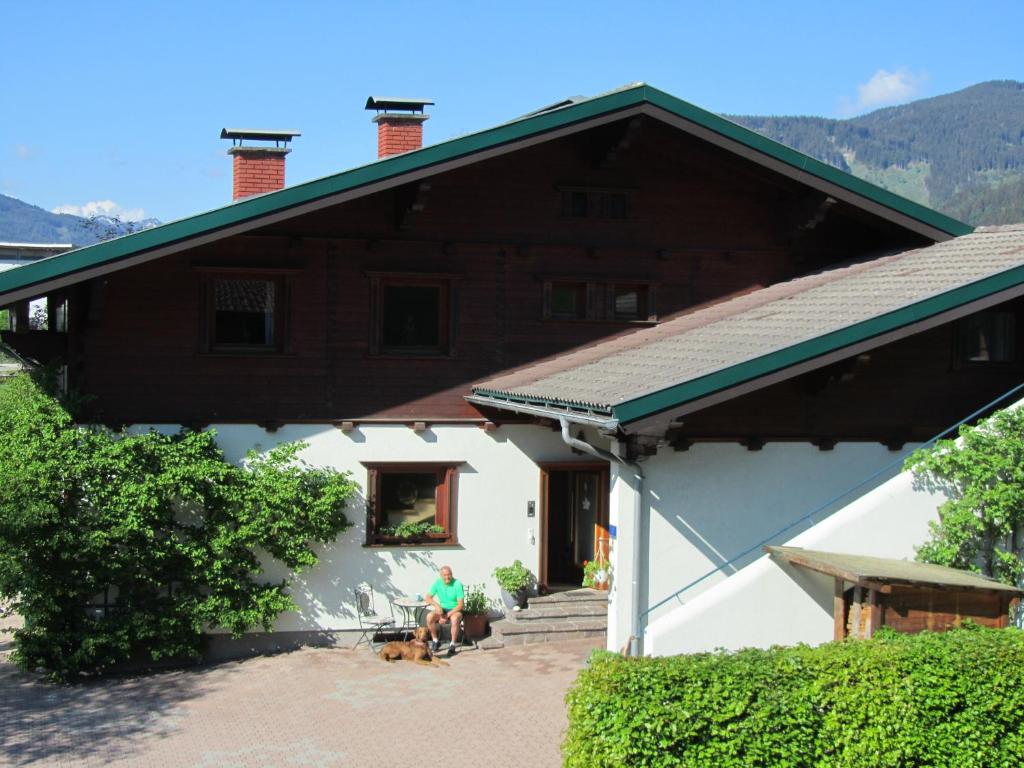 a man sitting on the porch of a house at Ferienwohnung Familie Wieser in Altenmarkt im Pongau