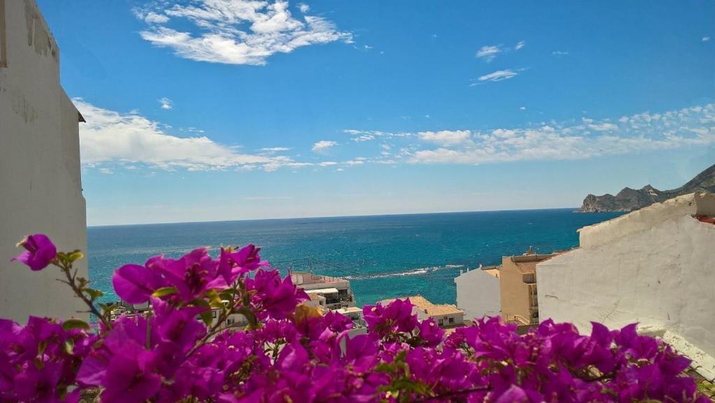 un montón de flores púrpuras al lado de un edificio en Piso Mettenza, en Altea