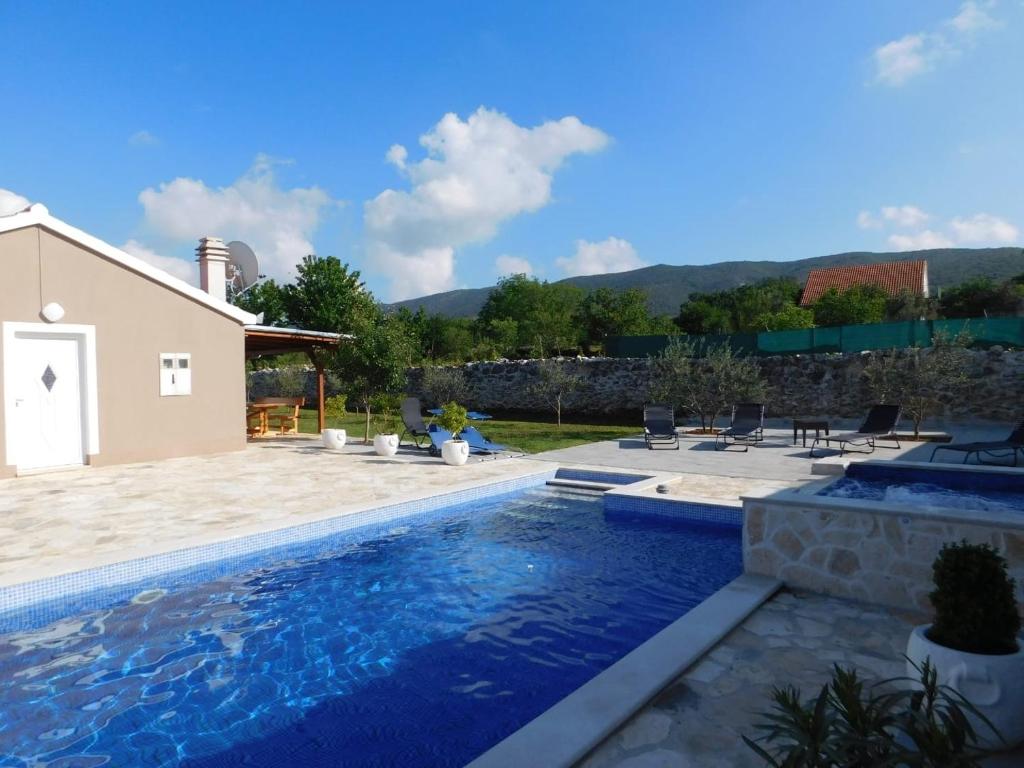 a swimming pool in front of a house at Vacation house Radosic in Radošić