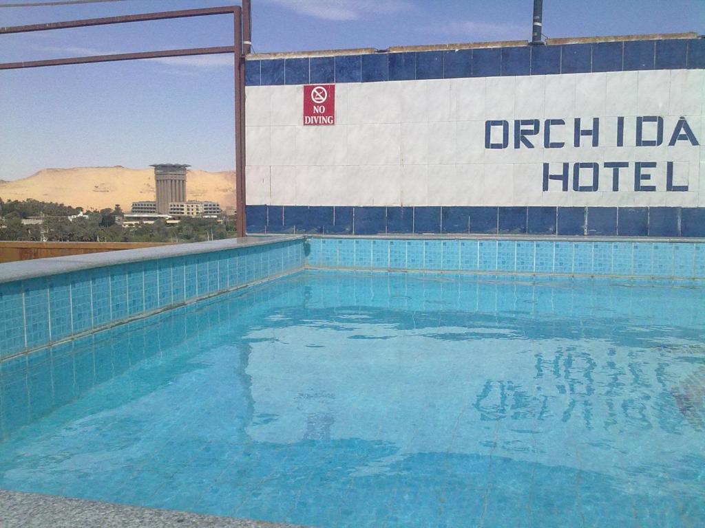 a swimming pool with a sign on the side of a hotel at Orchida St. George Hotel in Aswan