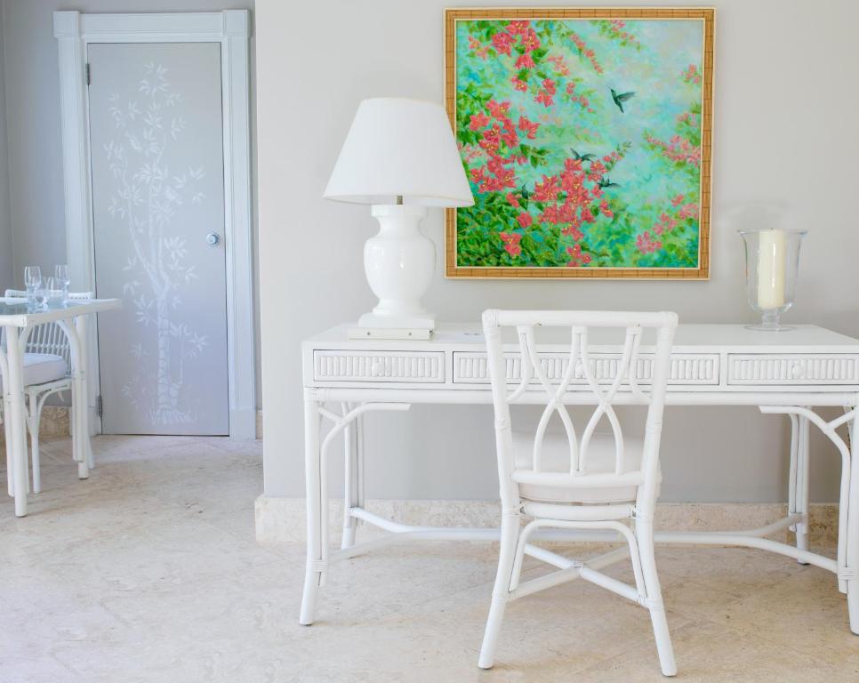 a white desk with a white chair and a painting at Cobblers Cove - Barbados in Saint Peter