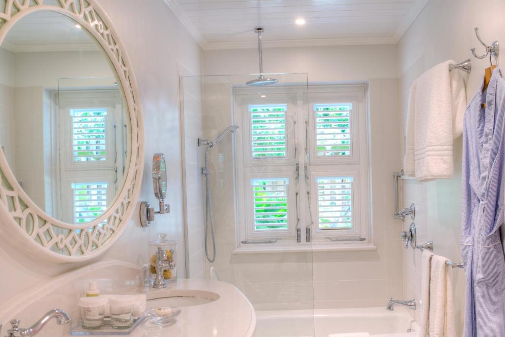 a white bathroom with a sink and a mirror at Cobblers Cove - Barbados in Saint Peter