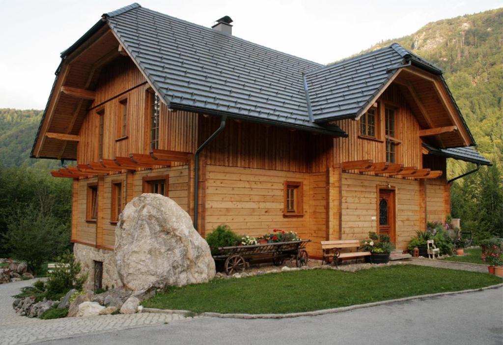 ein Blockhaus mit einem großen Felsen davor in der Unterkunft Apartment Pod Skalco in Jesenice