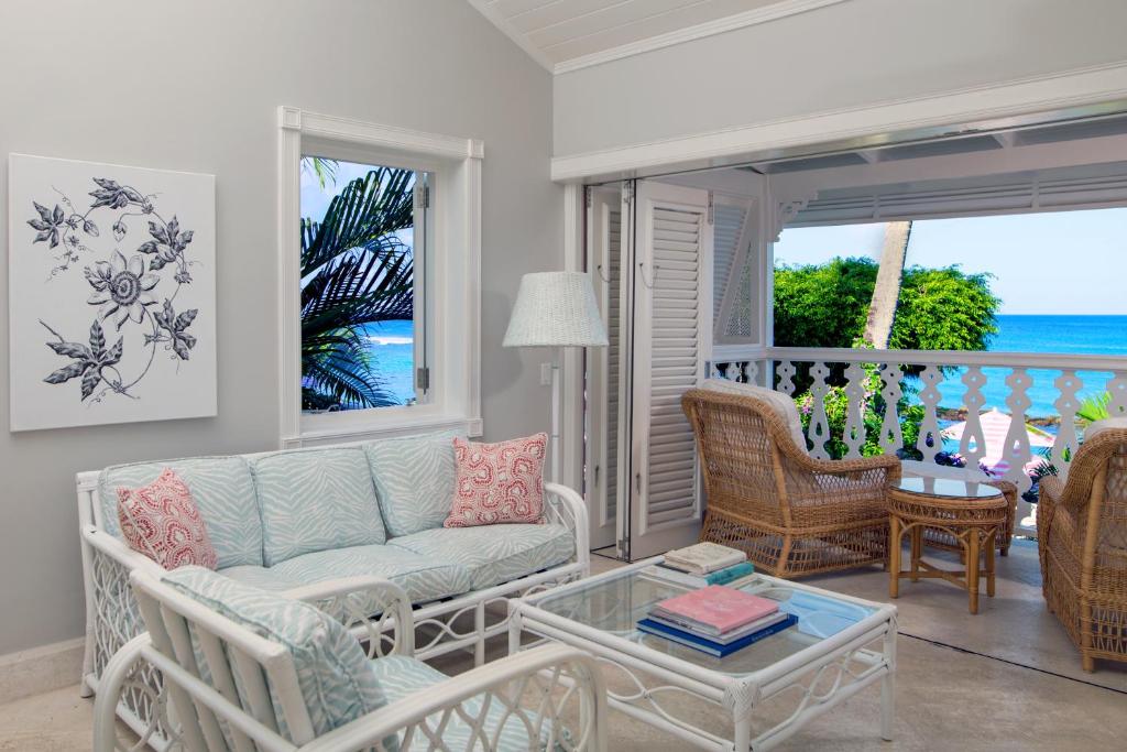 a living room with a couch and chairs and a balcony at Cobblers Cove - Barbados in Saint Peter