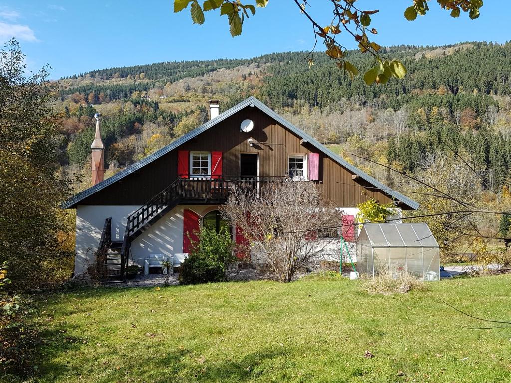 a house on a hill with a church at La Beuratte in Cornimont