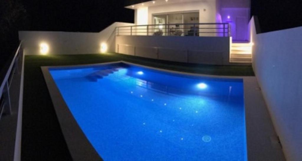 uma grande piscina em frente a uma casa em DuMar Beachouse em Salema