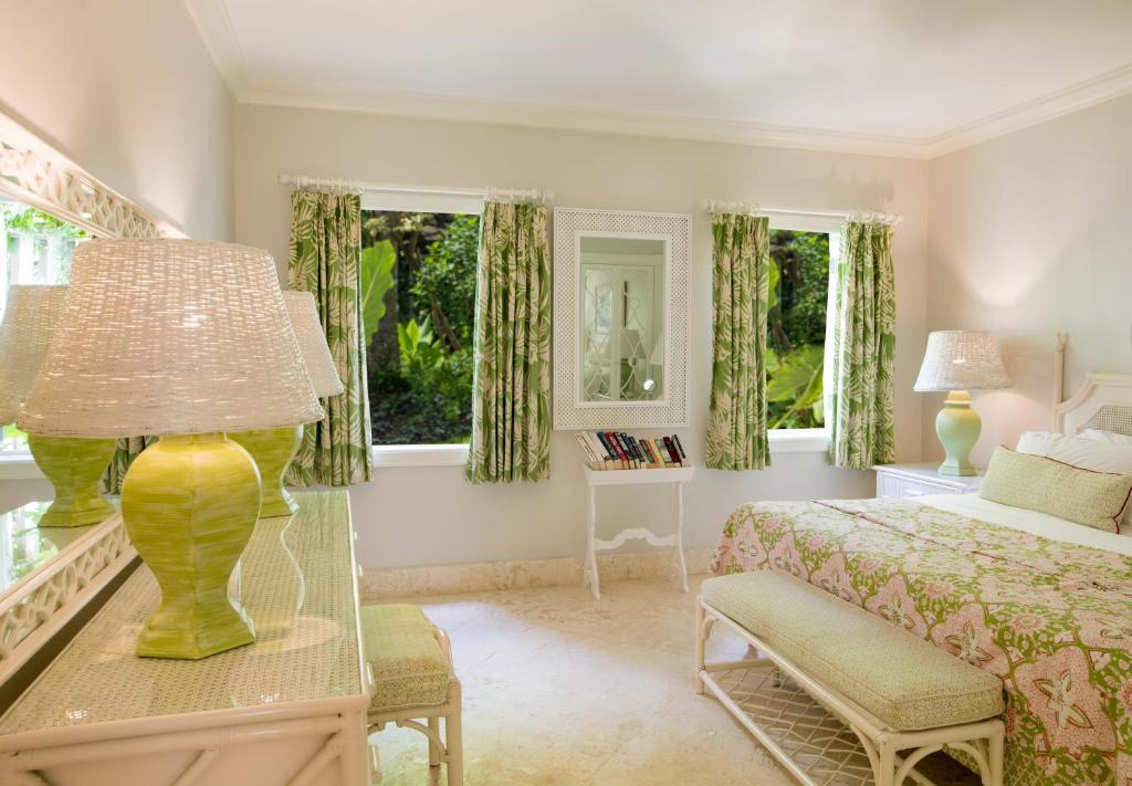 a bedroom with a bed and a table with a lamp at Cobblers Cove - Barbados in Saint Peter