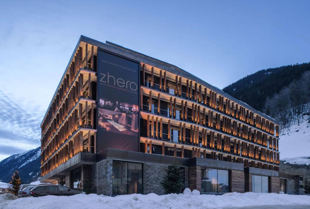 ein Gebäude im Schnee mit einer Plakatwand darauf in der Unterkunft Hotel Zhero – Ischgl/Kappl in Kappl