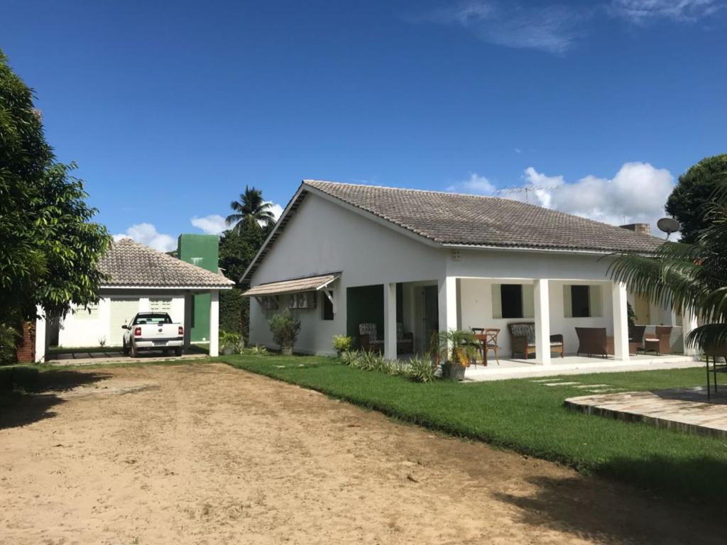 a house with a car parked in the driveway at Serrambi - 4 quartos com piscina e churrasqueira in Porto De Galinhas