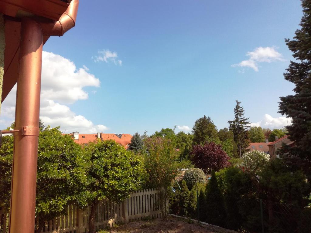 a view of a garden with a fence and trees at CORSO Central Home, Keszthely in Keszthely