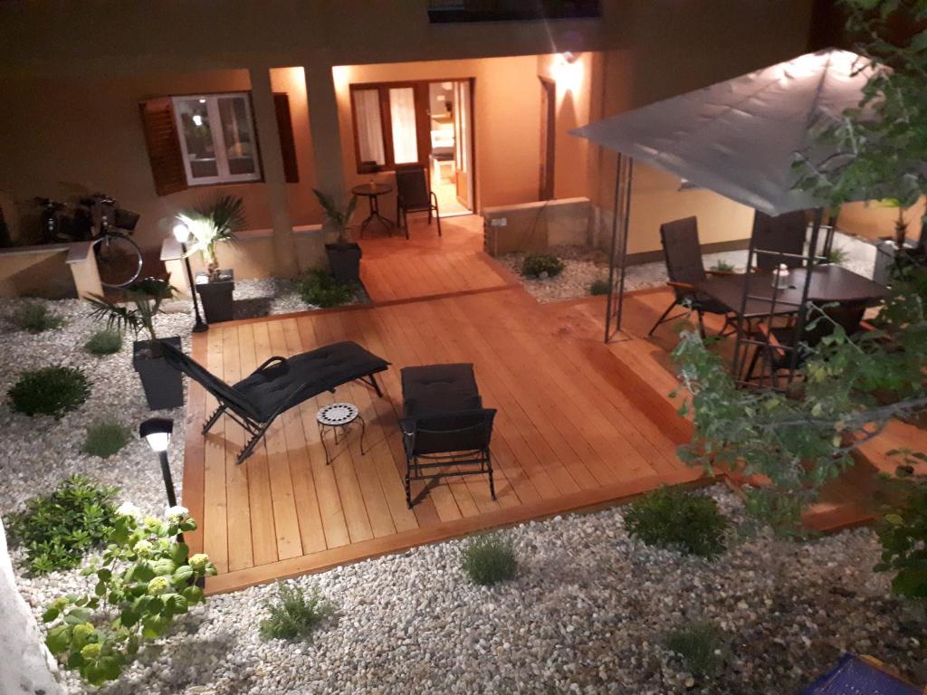 z widokiem na drewniany taras z krzesłami i stołami w obiekcie Exclusive city center apartment with garden w Rovinj