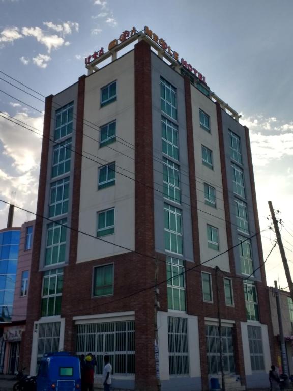 a tall red and white building on a street at Mekelle Hotel in Mekʼelē