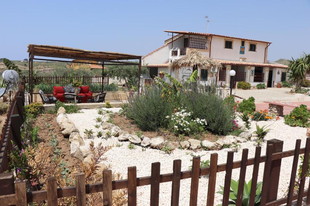 a garden with a fence in front of a house at Casa Vacanza Villa Sole in Siculiana