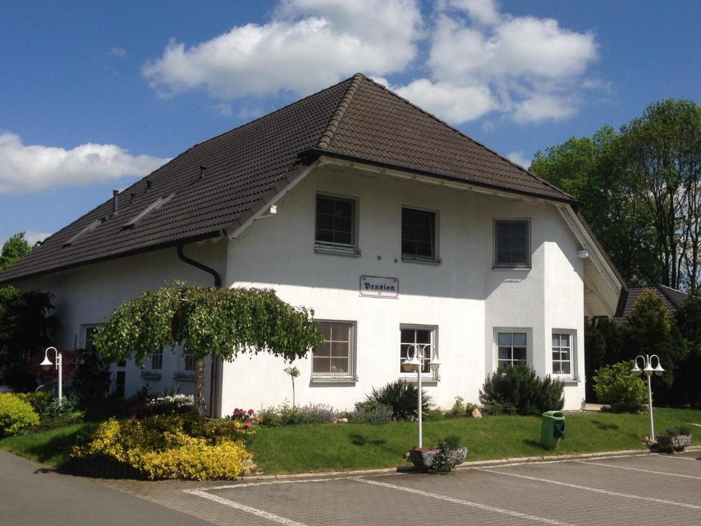 une maison blanche avec un toit marron dans l'établissement Pension Egerer, à Bad Köstritz