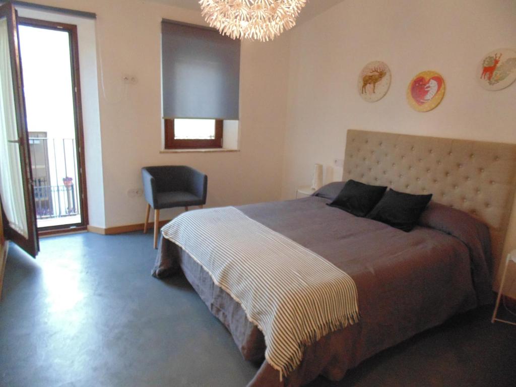 Un dormitorio con una cama grande y una lámpara de araña. en Apartamentos 14DeSande, en Cáceres