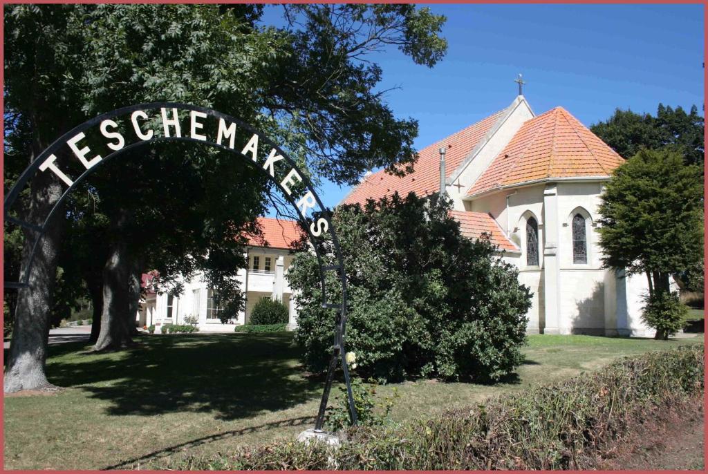 um edifício com uma placa em frente a uma casa em Teschemakers Resort em Oamaru