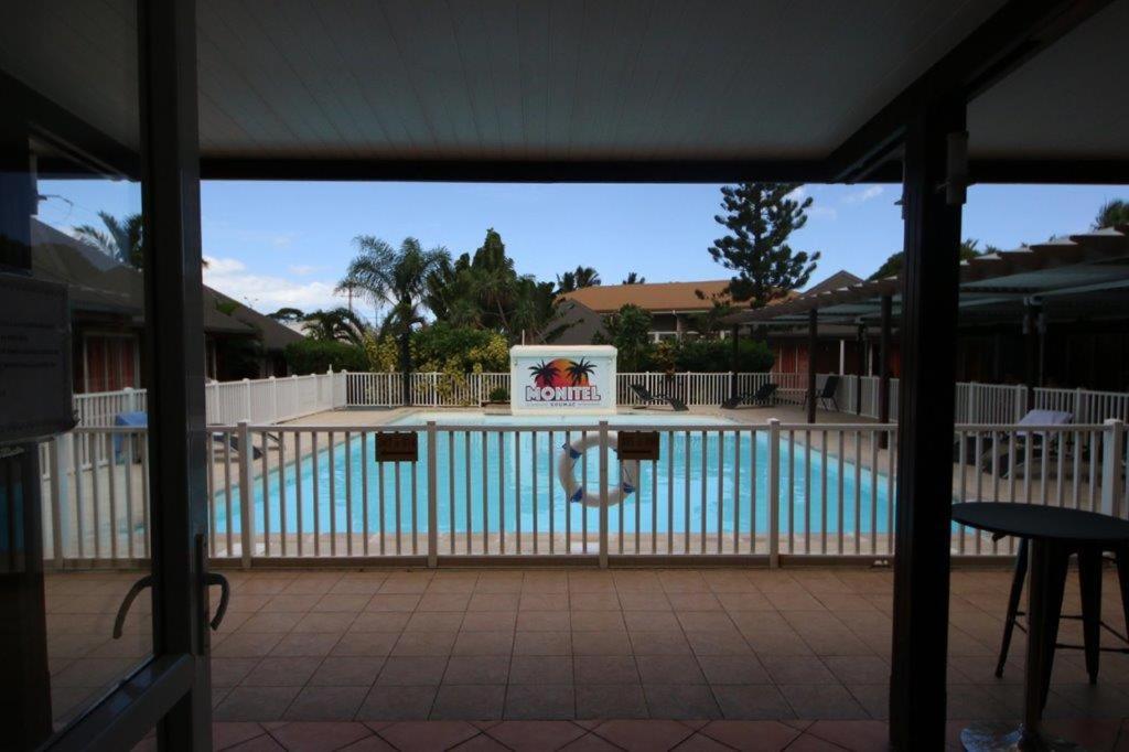 a view of a swimming pool with a sign on a fence at Monitel in Kumak