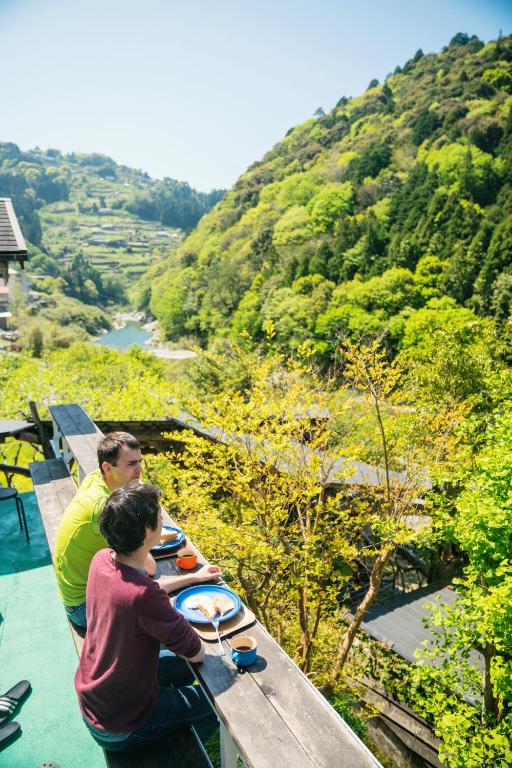 a man and a boy standing at a table with plates of food at Momonga Village in Miyoshi