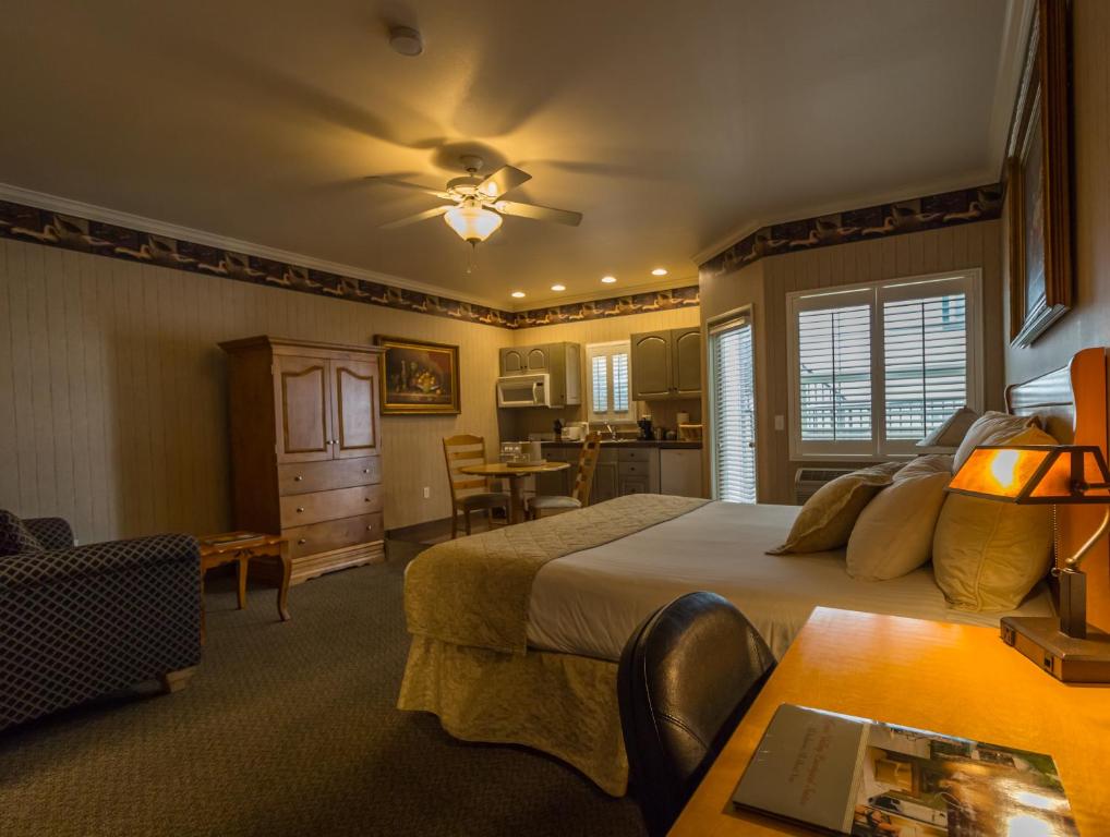 a bedroom with a bed and a table and a dining room at Grass Valley Courtyard Suites in Grass Valley