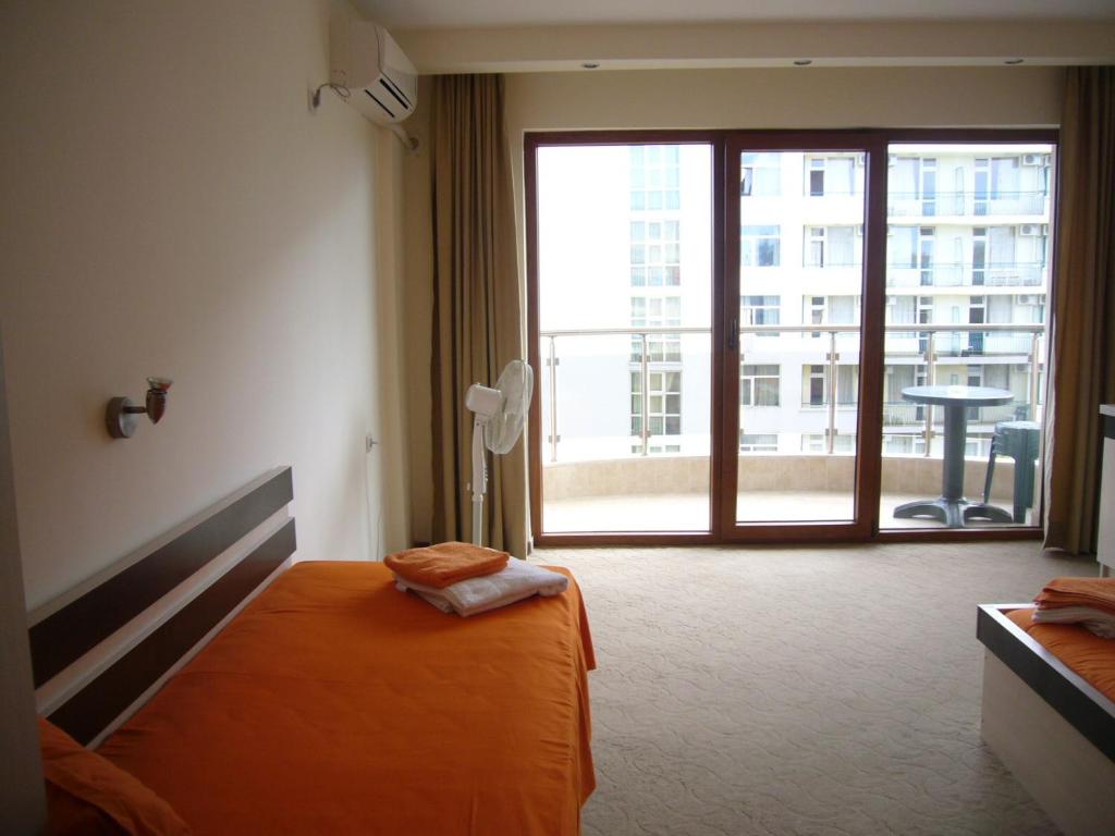 a hotel room with a bed and a large window at Family Hotel Golden Lion in Primorsko