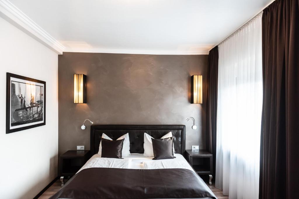 ケルンにあるモーリチウス コムフォー ホテル イン デア アルシュタットの黒い壁のベッドルーム1室(大型ベッド1台付)