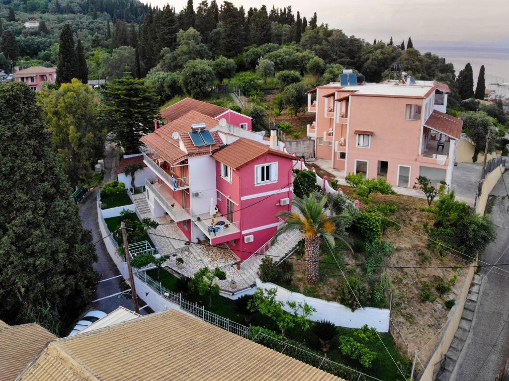 una casa rosa en la cima de una colina en Skevoulis Studios, en Benitses