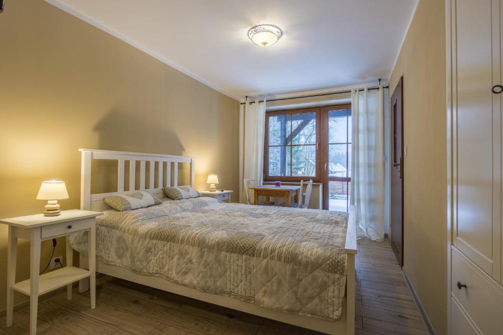 シュクラルスカ・ポレンバにあるWilla z Widokiemのベッドルーム(大型ベッド1台、窓付)