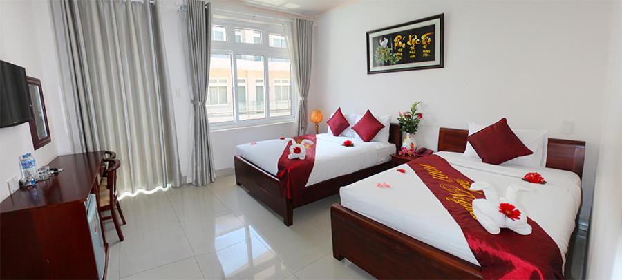 a hotel room with two beds and a window at 1001 Nights Hotel in Mui Ne