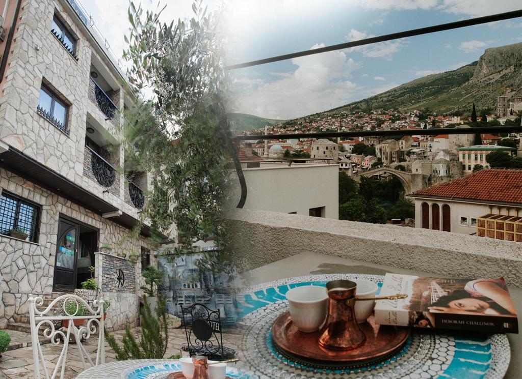 a table on a balcony with a view of a city at Villa Anri in Mostar