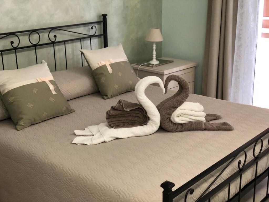 アヴォラにあるMaison Bijou B&Bの白鳥2羽がベッドに座ってタオルを持っている