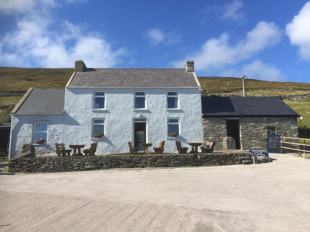 a white house with benches in front of it at Old Irish farmhouse in Dingle